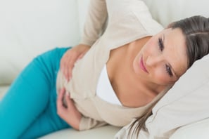 Woman lying on sofa looking sick in the living room